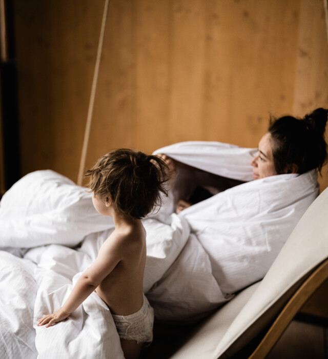 Mutter und Sohn entspannen in der Bettdecke auf einem Hängestuhl