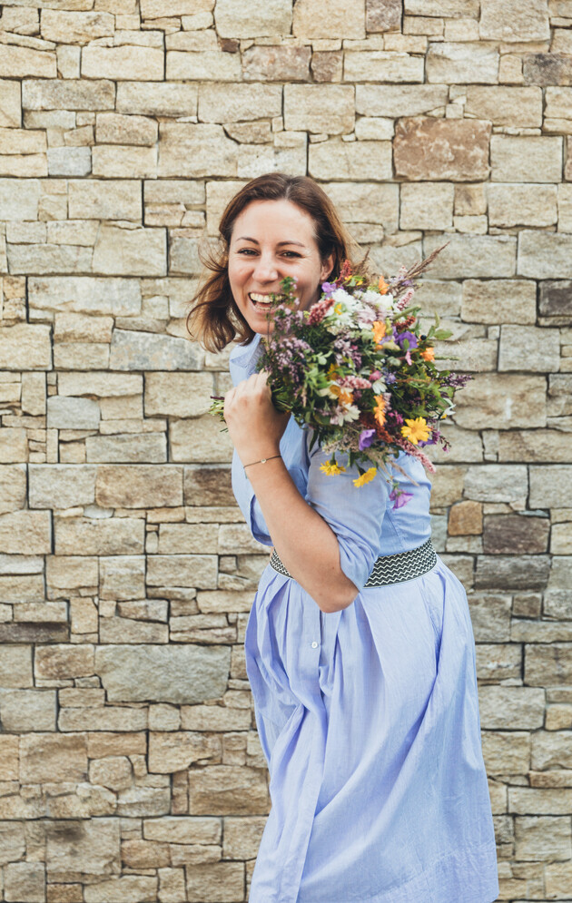 Tina Neudegger mit Blumenstrauß, Ihre herzliche Gastgeberin im Hotel Nesslerhof in Großarl, Salzburger Land