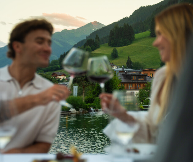 Pärchen genießt ein Glas Wein beim Dinner zu zweit am Naturbadeteich