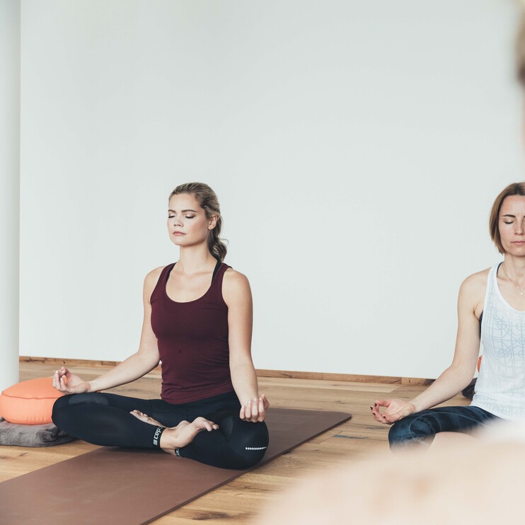Damen im Schneidersitz beim Yoga im Urlaub in Großarl